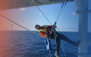 Training for new offshore jobs in 2025 man using safety apparatus hanging from oil rig