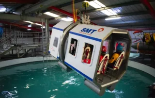 Stream Marine Training HUET Simulator hangs over the pool while delegates await instructions strapped inside