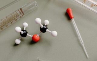 Molecular model representing ammonia and methanol compounds beside lab equipment, symbolising new marine fuel technology and safety training for seafarers.
