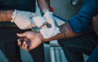 Instructor demonstrating correct bandaging technique during STCW medical training, showing practical first aid skills for seafarers and workplaces.
